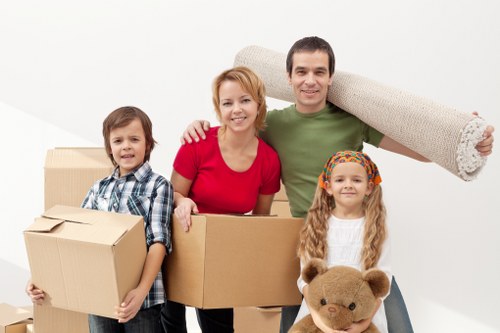 Professional movers carrying furniture through a Battersea property